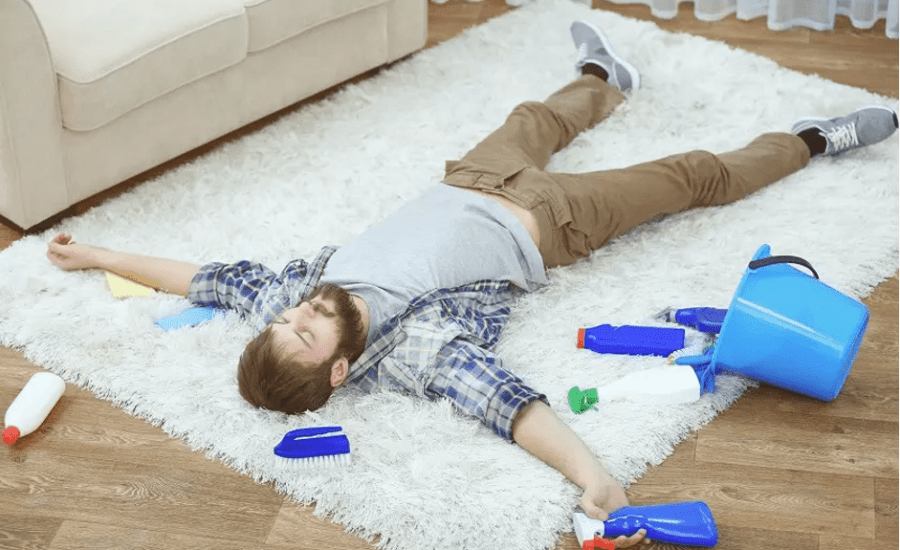 уставший мужчина лежит на ковре после чистки вручную